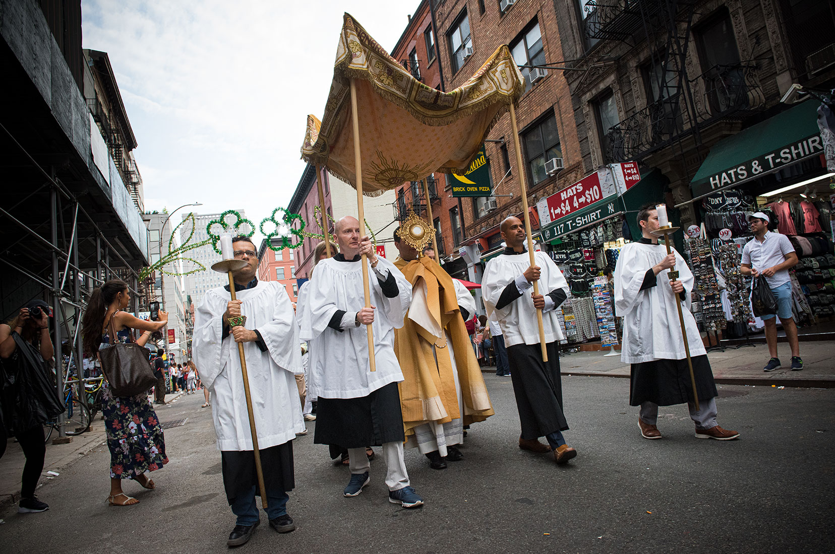 A Eucharistic procession moves through the streets of Little Italy in New York